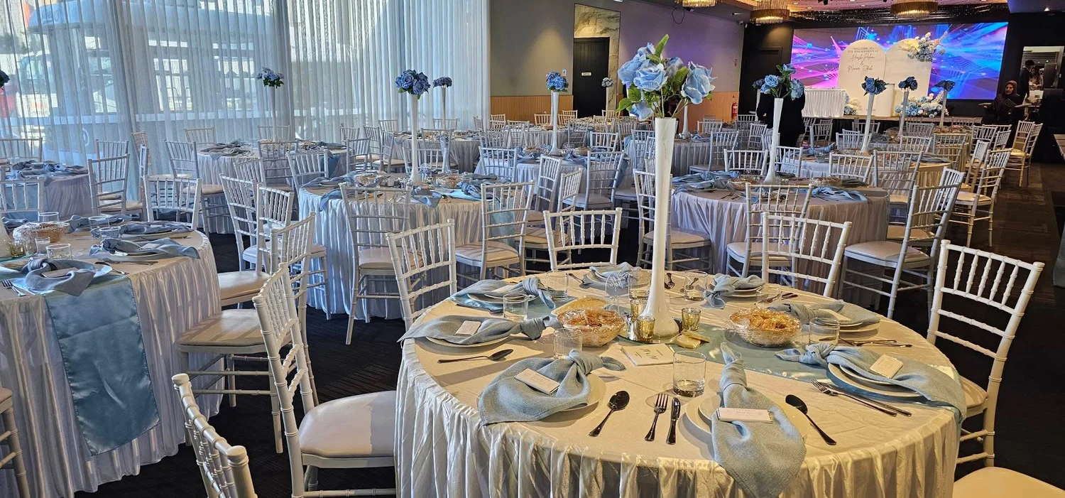 Elegant blue banquet tables and floral centrepieces inside The Vibes Venue