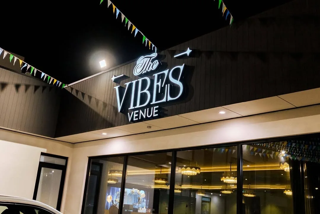 Night-time exterior of The Vibes Venue with its illuminated sign and entrance